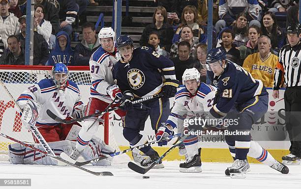 Patrik Berglund of the St. Louis Blues handles the puck in front of Chris Drury of the New York Rangers while Matt Gilroy of the New York Rangers...