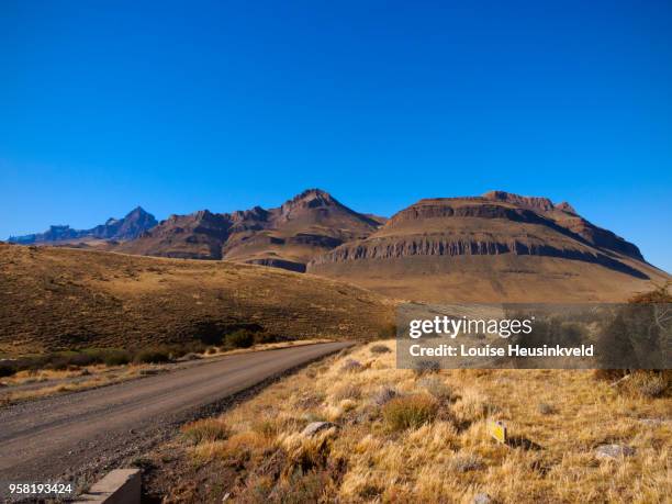 sierra baguales, patagonia, chile. track leading to the mountain range on the border of argentina. - argentina dirt road panorama stock pictures, royalty-free photos & images