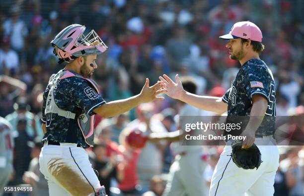 Brad Hand of the San Diego Padres, right, is congratulated by Raffy Lopez after getting the final out in the ninth inning of a baseball game against...