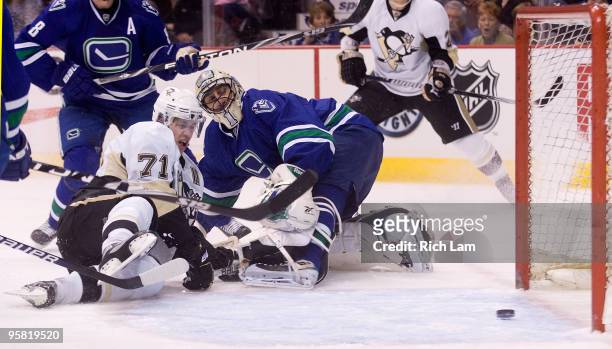 Goalie Roberto Luongo of the Vancouver Canucks watches Evgeni Malkin of the Pittsburgh Penguins' shot slide into the net during the first period of...