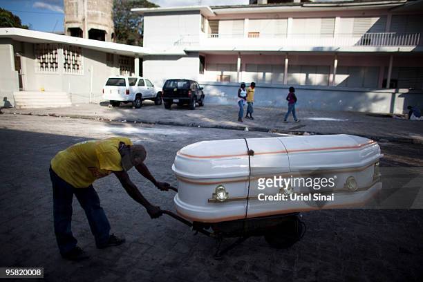 Man caries a coffin at the city hospital on January 16, 2010 in Port-au-Prince, Haiti. Haiti is trying to recover from a powerful 7.0-strong...