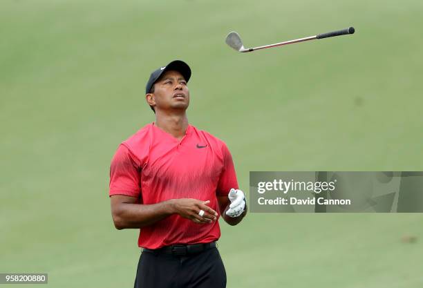 Tiger Woods of the United States tosses his wedge in frustration after his second shot on the par 4, 14th hole spun back off the green during the...