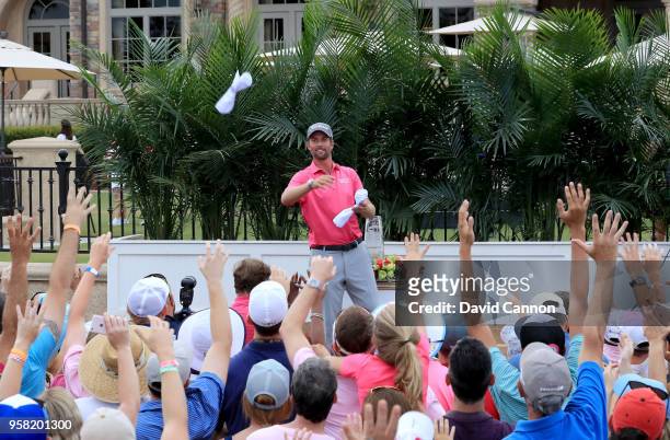 Webb Simpson of the United States throws signed pin flags to the crowd at the presentation ceremony after he had secured a four stroke victory during...