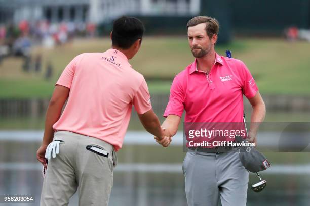 Webb Simpson of the United States shakes hands with Danny Lee of New Zealand on the 18th green after winning during the final round of THE PLAYERS...