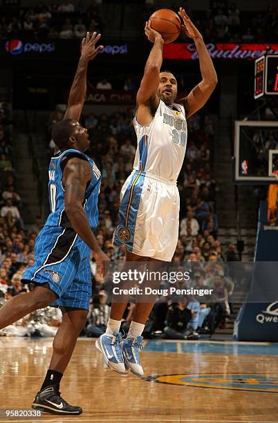 Malik Allen of the Denver Nuggets takes a shot against Brandon Bass of the Orlando Magic during NBA action at Pepsi Center on January 13, 2010 in...