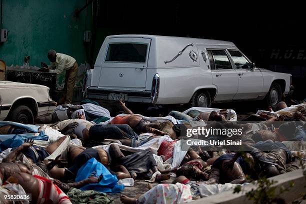 Man stands among dead bodies at the yard of the general hospital's morgue on January 16, 2010 in Port-au-Prince, Haiti. Haiti is trying to recover...