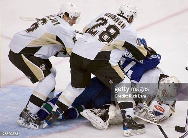 Darcy Hordichuk of the Vancouver Canucks falls on goalie Alexander Pechurski of the Pittsburgh Penguins while teammates Ben Lovejoy and Eric Godard...