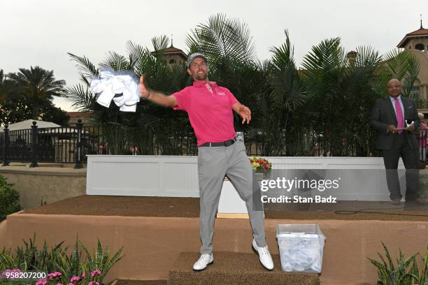 Webb Simpson throws out signed pin flags to fans during the trophy ceremony after the final round of THE PLAYERS Championship on THE PLAYERS Stadium...