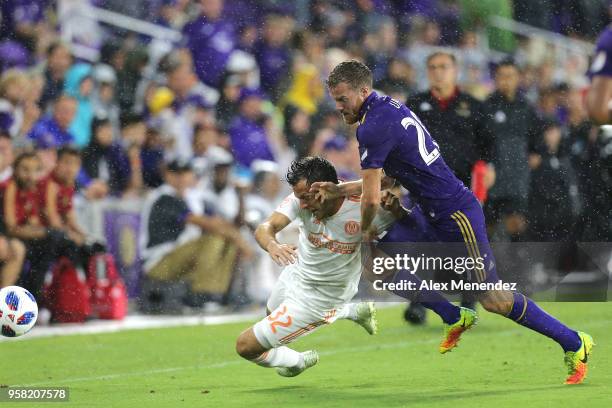 Kevin Kratz of Atlanta United FC and Oriol Rosell of Orlando City SC fight for the loose ball during a MLS soccer match at Orlando City Stadium on...