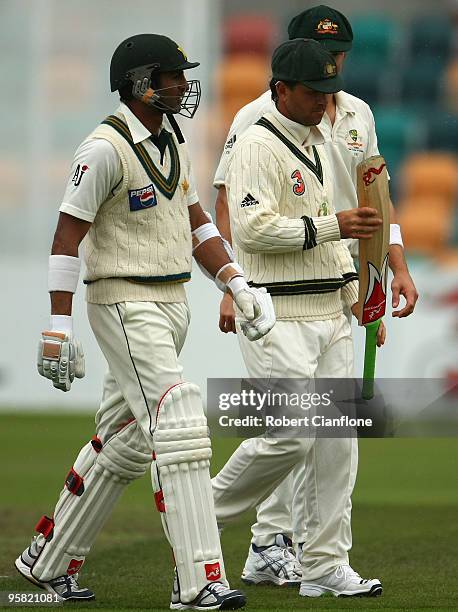 Ricky Ponting of Australia has a look at the bat used by Shoaib Malik of Pakistan as the teams walk off the ground due to rain during day four of the...