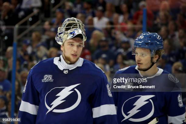 Andrei Vasilevskiy of the Tampa Bay Lightning talks with teammate Mikhail Sergachev against the Washington Capitals during the first period in Game...