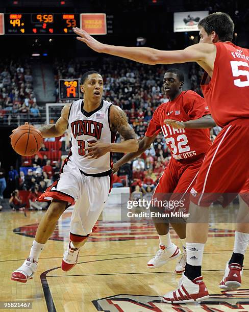 Tre'Von Willis of the UNLV Rebels drives against Shawn Glover and David Foster of the Utah Utes during their game at the Thomas & Mack Center January...