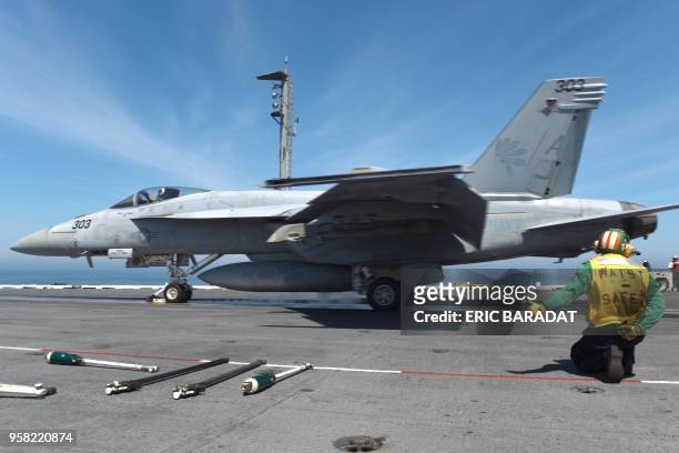 Catapult officer gestures as a US Navy F/18 Hornet takes off from the USS George H.W. Bush aircraft carrier on May 11, 2018 in the Atlantic Ocean. -...