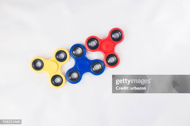 fidget spinners on white - spinning gyroscope stock pictures, royalty-free photos & images