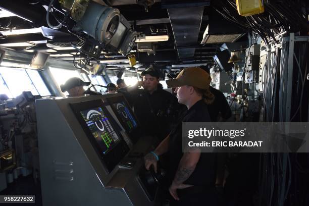 Young officer stands at the helm of the ship in the command post of the USS George H.W. Bush aircraft carrier on May 11, 2018 in the Atlantic Ocean....