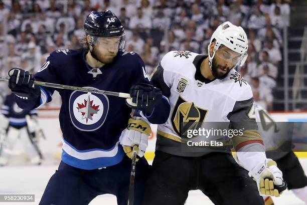 Pierre-Edouard Bellemare of the Vegas Golden Knights grabs the puck as Joel Armia of the Winnipeg Jets defends in Game One of the Western Conference...