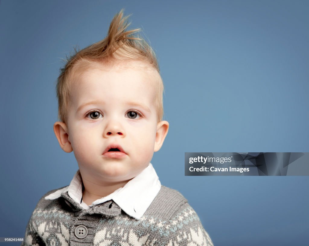 Portrait Of Baby Boy With Spiky Hair Against Blue Background High-Res Stock  Photo - Getty Images