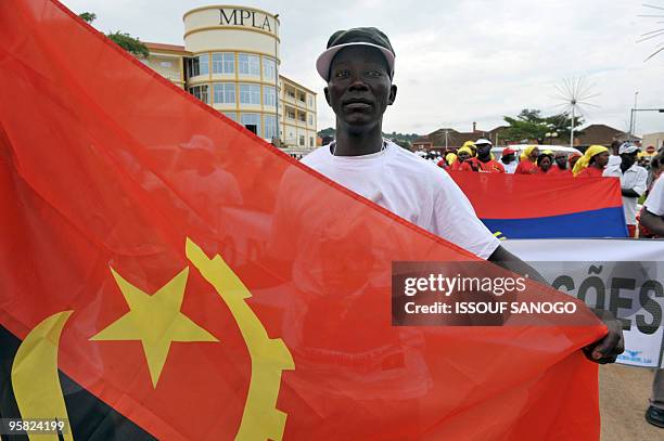 Man holds Angola's flag as he attends a rally against violence on January 16, 2010 in Cabinda following the attack against Togo's national football...