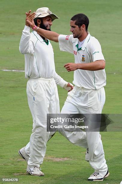 Wayne Parnell of South Africa celebrates the wicket of Kevin Pietersen of England with team mate, Hashim Amla during day 4 of the 4th Test match...