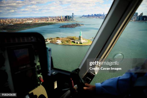 statue of liberty amidst bay seen through helicopter window - helicopter stock pictures, royalty-free photos & images