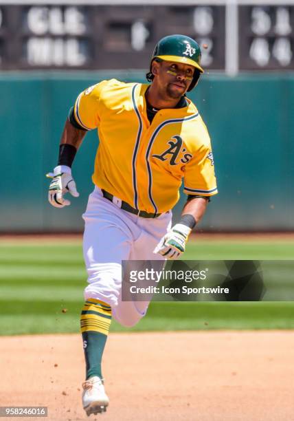 Oakland Athletics Designated hitter Khris Davis heads into third base while the ball is still in play during the game between the Houston Astros and...