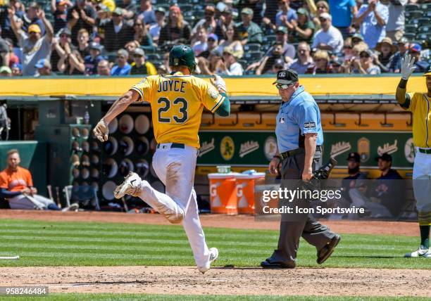 Oakland Athletics Outfield Matt Joyce tags at home for the first score in the game between the Houston Astros and the Oakland Athletics on May 9,...