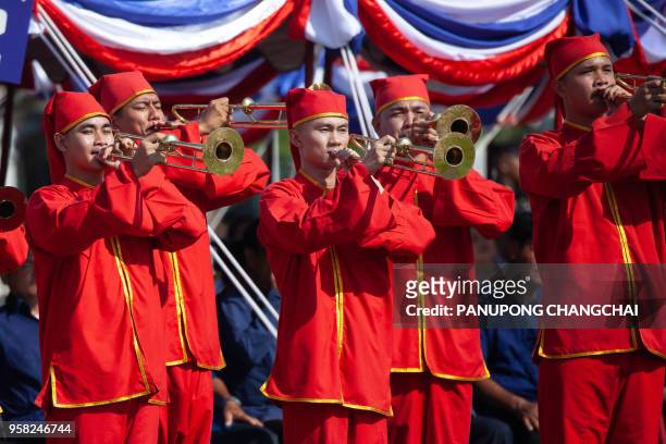 Men in colorful costumes participate in the annual royal ploughing ceremony presided by Thai King Maha Vajiralongkorn outside Bangkok's royal palace...