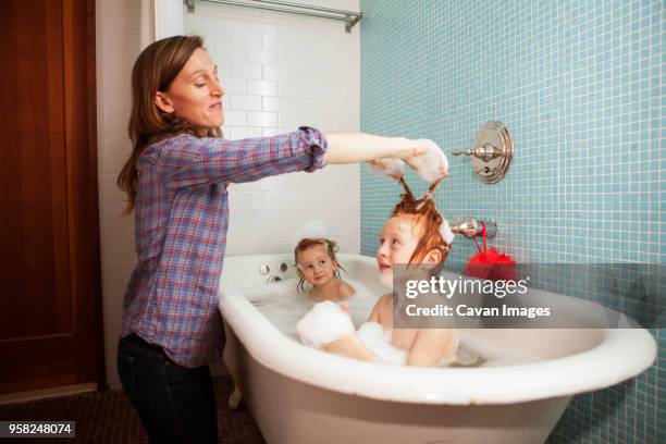 mother bathing kids in bathtub - brothers bathroom bildbanksfoton och bilder