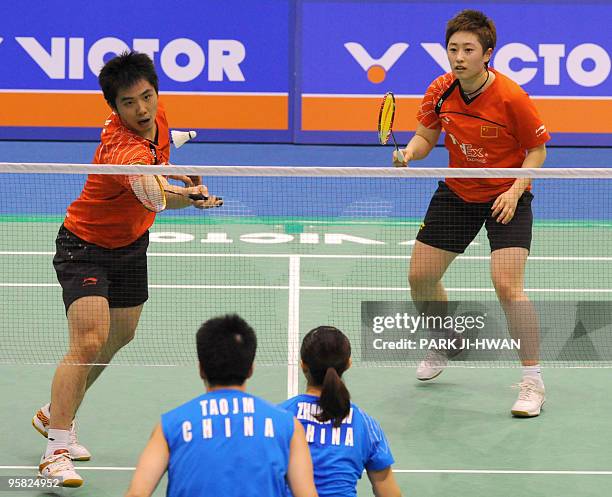 China's He Hanbin returns a shot as his teammate Yu Yang watches during their mixed doubles final match against China's Tao Jiaming and Zhang Yawenat...