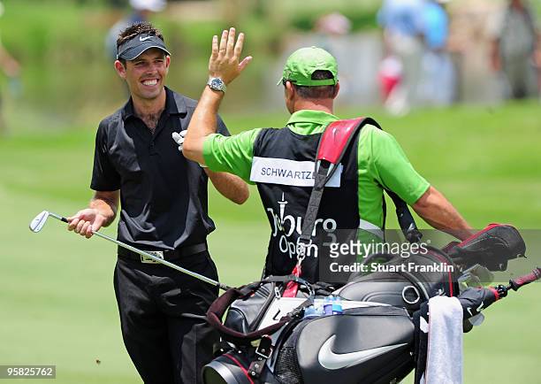 Charl Schwartzel of South Africa celebrates with his caddie on the 14th hole during the final round of the Joburg Open at Royal Johannesburg and...