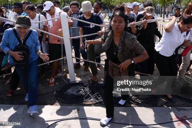 Attendees run to collect 'sacred' rice grains from the ground after the Royal Ploughing Ceremony at the Sanam Luang park in Bangkok, Thailand on May...