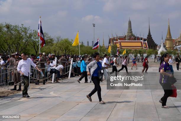 Attendees run to collect 'sacred' rice grains from the ground after the Royal Ploughing Ceremony at the Sanam Luang park in Bangkok, Thailand on May...