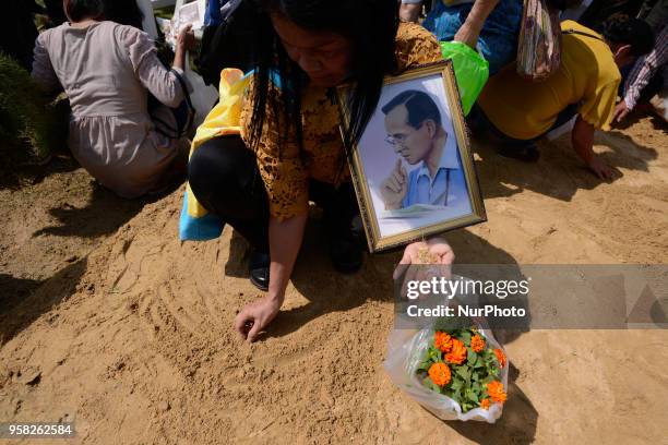 Attendees run to collect 'sacred' rice grains from the ground after the Royal Ploughing Ceremony at the Sanam Luang park in Bangkok, Thailand on May...