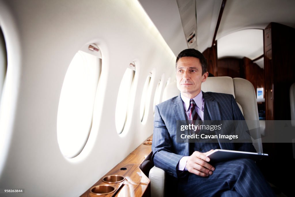 Thoughtful businessman traveling in corporate jet