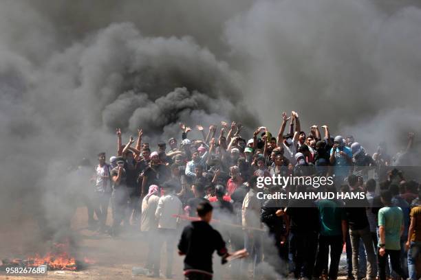 Palestinian demonstrators burn tyres near the Gaza-Israel border, east of Gaza City, as Palestinians readied for protests over the inauguration of...