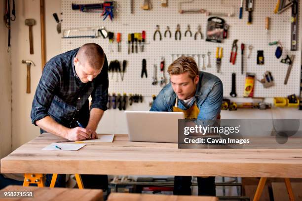 male carpenters working on wood in workshop - tool rack stock pictures, royalty-free photos & images