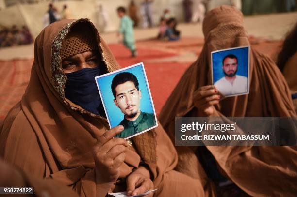 In this picture taken on May 13 women show pictures of their missing relatives at a protest rally in Karachi. - The PTM came to prominence in...
