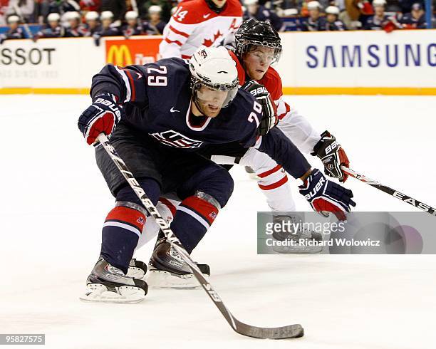 Jerry D'Amigo of Team USA skates with the puck while being defended by Ryan Ellis of Team Canada during the 2010 IIHF World Junior Championship...