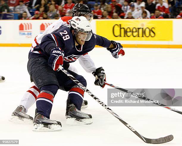 Jerry D'Amigo of Team USA skates with the puck while being defended by Ryan Ellis of Team Canada during the 2010 IIHF World Junior Championship...