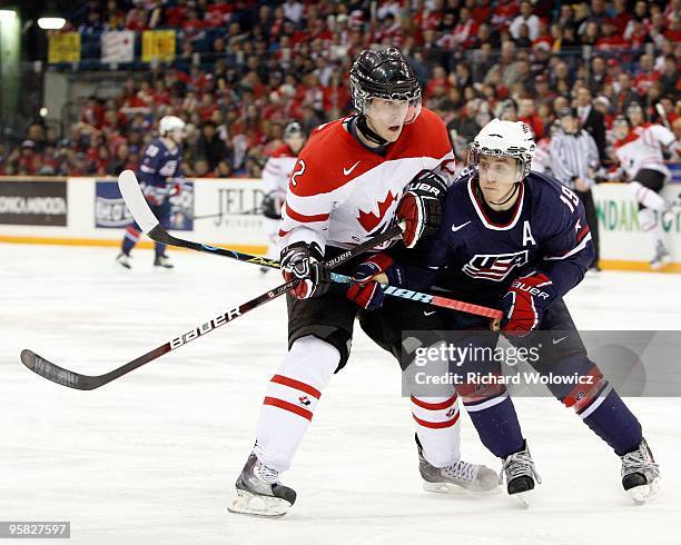 Jordan Schroeder of Team USA and Colten Teubert of Team Canada chase the puck into the corner during the 2010 IIHF World Junior Championship...