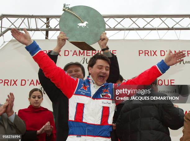 Le Romain Giampaolo Minucci , driver du cheval italien Varenne, lève les bras en signe de victoire, pendant que son entraîneur Jori Turja brandit, le...