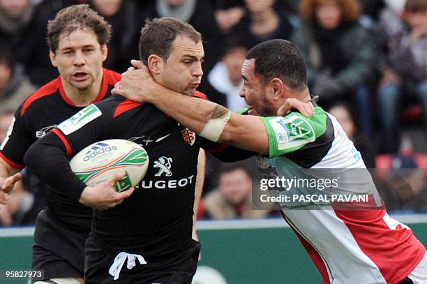 Toulouse's outside-half Jean-Baptiste Elissalde collapses with London Harlequins's hooker Tani Fuga during their European Cup rugby union match...