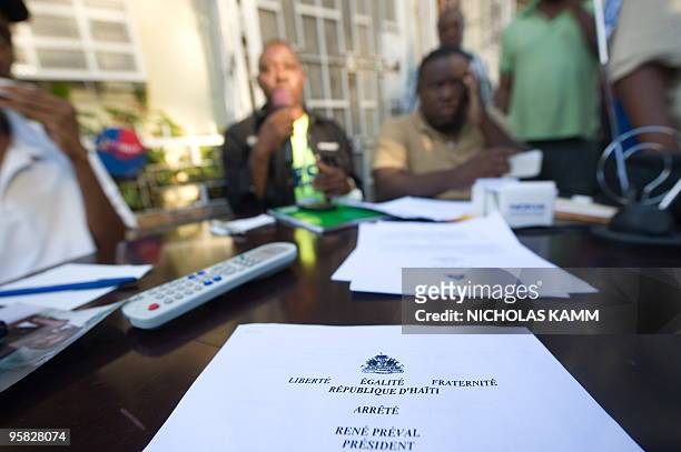 An announcement by Haitian President Rene Preval lies on the table as Radio Caraibes presenter Israel Jacky Cantave broadcasts from the street across...