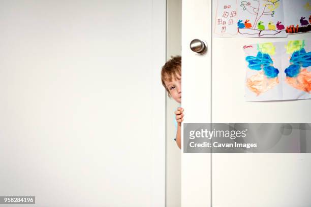 portrait of boy behind door at home - children room wall stock pictures, royalty-free photos & images