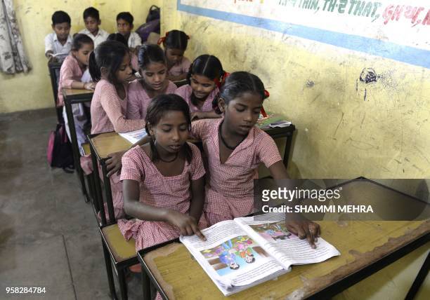 Indian school children sit in a classroom before taking vaccination for measles and rubella at a government school in Jalandhar on May 14, 2018. -...