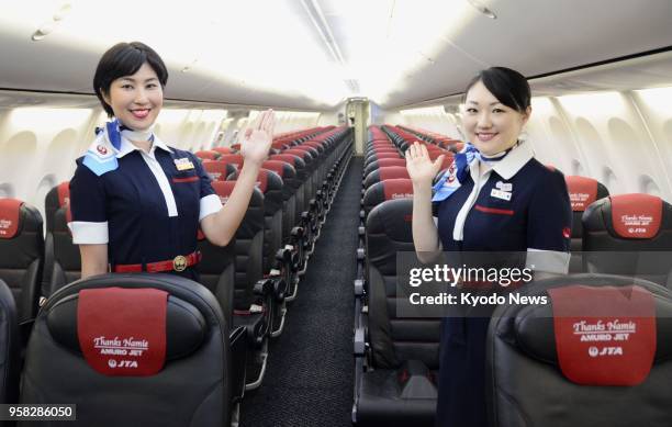 Japan Transocean Air flight attendants pose inside a special jet decked out with headrest covers thanking Okinawa-born singer Namie Amuro in Naha,...