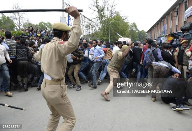 Indian police try to push back Kashmiri teachers during a protest against the government in Srinagar on May 14, 2018. - Police used water cannon and...