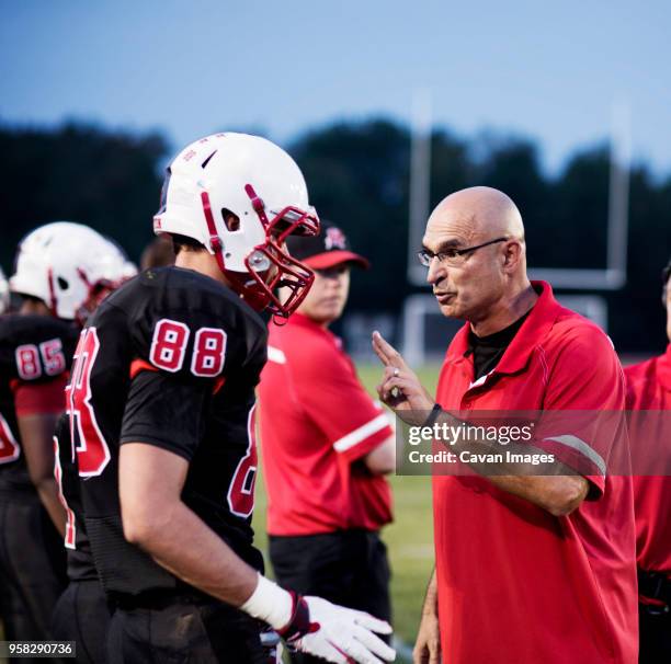 coach explaining american football players on field - american football coach stock pictures, royalty-free photos & images