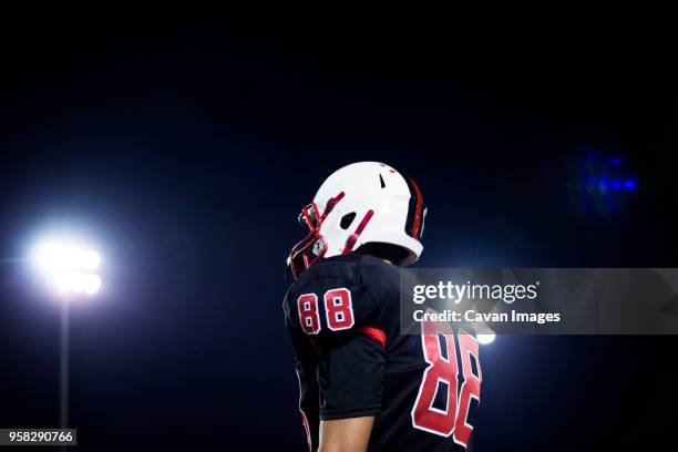 low angle view of teenage american football players standing against sky at night - safety american football player stockfoto's en -beelden