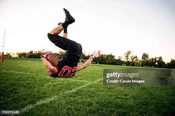 boy jumping with american football on playing field - safety american football player bildbanksfoton och bilder